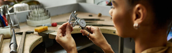 Талантливый ювелир исследует замысловатые детали красивых драгоценностей в своем творческом пространстве.