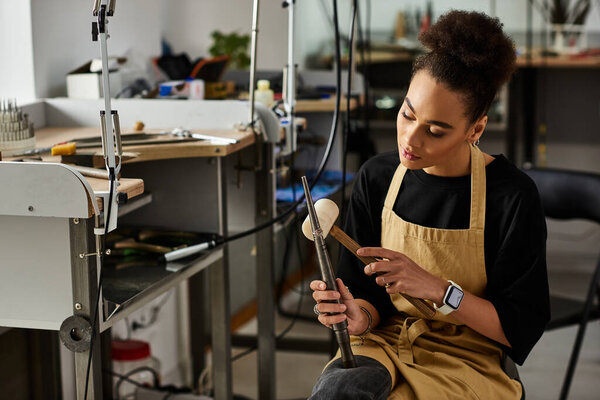 A talented woman passionately designs an exquisite jewel while seated at her creative workspace.