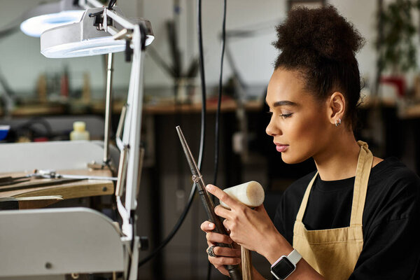 A skilled woman meticulously designing stunning jewelry while working in her workshop.