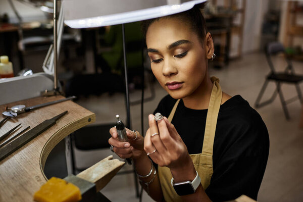 A talented jeweler focuses intently on creating a stunning piece with precision tools.