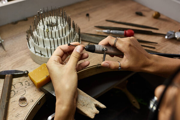 An artisan focuses on crafting a beautiful piece of jewelry with precision and care.