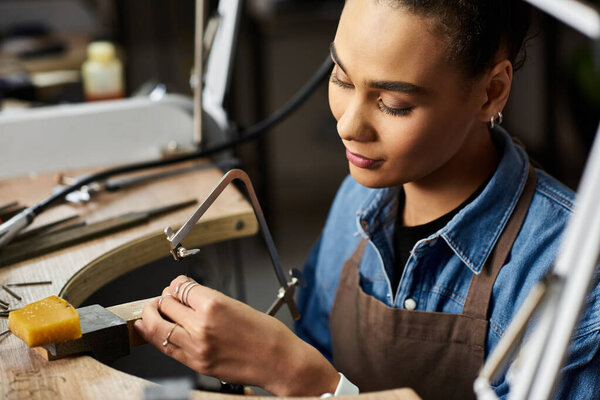 An artisan focused on jewelry design, working attentively in her creative workspace.