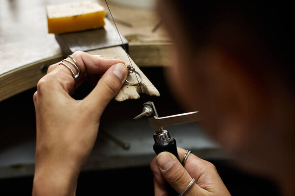 A talented woman creates stunning accessories while focused and immersed in her craft.