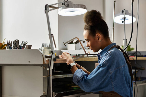 A talented craftsperson focuses on creating beautiful jewelry within a well equipped workspace.