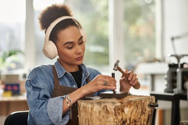 Yetenekli bir kadın stüdyosunda müzik dinlerken tutkulu bir şekilde zarif mücevherler yapar..
