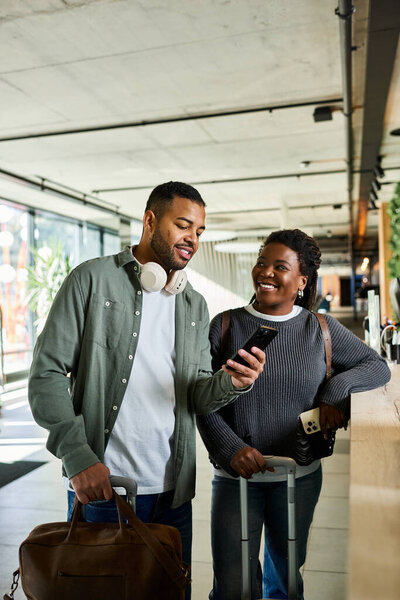 Молодая афроамериканская пара улыбается и делит мгновение вместе, останавливаясь в отеле для отдыха.