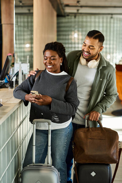 Радостная пара ждет заселения в отель, делясь улыбками и волнением о предстоящем отпуске.