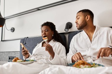 Genç bir çift otel odalarında dinlenirken kahvaltı ve tatil boyunca birbirlerine eşlik ederler..