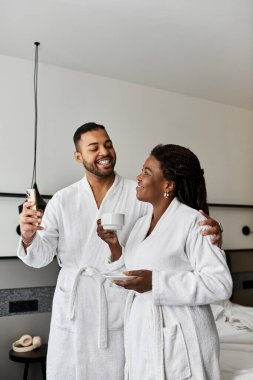 Genç bir çift gülümseme ve kahkaha paylaşıyor, lüks bir otel ortamında tatillerinin tadını çıkarıyorlar..