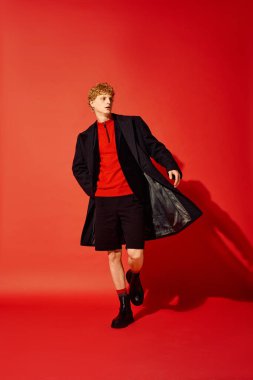 Şık bir adam, 2025 Noel 'i için çağdaş tatil kıyafetleri içinde güvenli bir şekilde şehir caddesinde yürüyor. Kıyafeti zarafet ve konforu birleştiriyor, şenlik ruhunu sergiliyor..