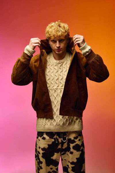 Модный мужчина уверенно стоит, натягивая свою стильную куртку в капюшоне. Он соединяет его с уютным вязаным свитером, воплощая дух Рождества 2025 года..