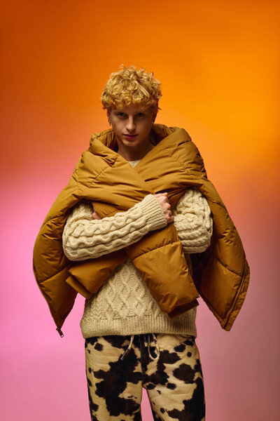 Стильный мужчина уверенно стоит в яркой праздничной моде, задрапированный в горчичный цветной наружный слой над уютным свитером.