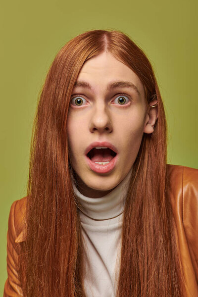 Young man expresses surprise with wide eyes and open mouth, showcasing vivid emotions.