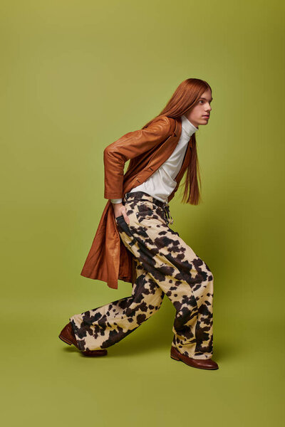 A young man with long red hair exhibits strong emotions while wearing a unique outfit.