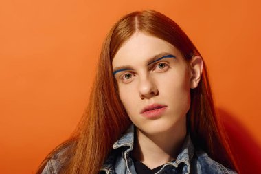 Uzun kızıl saçlı ve eşsiz mavi kaşlı duygusal genç adam izleyiciyle bağlantı kuruyor..