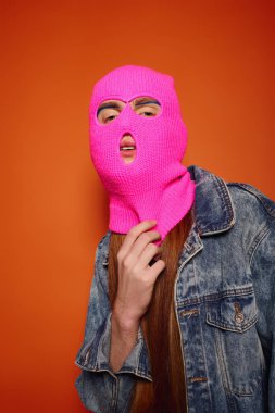 Büyüleyici kızıl saçlı genç adam çarpıcı pembe bir bere takarken duygularını açığa çıkarıyor..