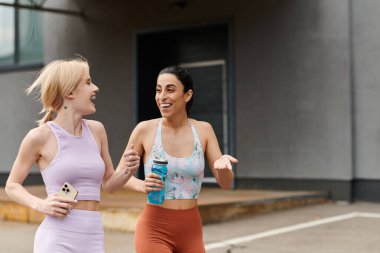 Two young women share joy while exercising together, fostering connection and support. clipart