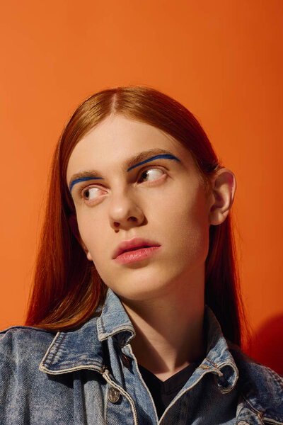 Young man with long red hair showcases a range of emotions in a vibrant setting.