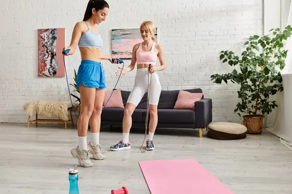 İki kadın, evlerinde atlama halatlarıyla ısınırken birbirlerine eşlik etmekten zevk alırlar..