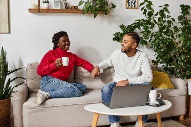 A couple enjoys quality time together in their cozy living room, surrounded by warmth and love. clipart