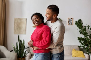 Neşeli bir çift, kış boyunca evlerinde rahat kazaklar giyip, sevgi dolu bir anın tadını çıkarırlar..