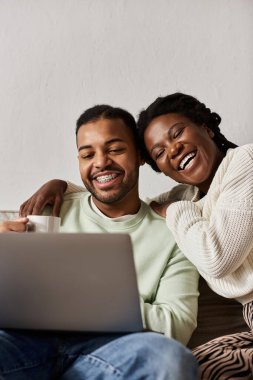 Mutlu bir çift, sıcak bir kış günü evde gülümseyerek ve dinlenerek birlikte vakit geçirmekten zevk alır..