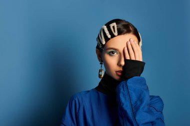 Young woman showcases her stylish outfit and playful hair accessories in a vibrant studio setting. clipart