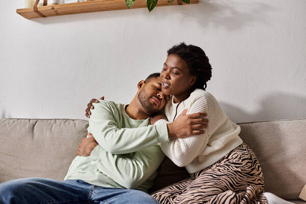 African American couple wearing cozy sweaters during winter, woman comforting her sad man