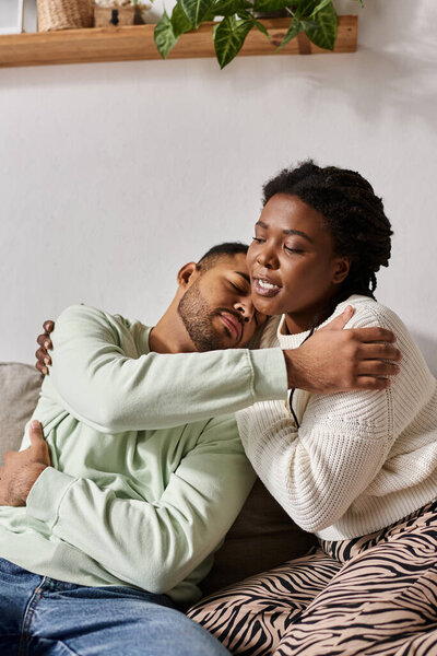 African American couple wearing cozy sweaters during winter, woman comforting her partner