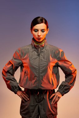 Güzel bir genç kadın, moda kıyafetlerini bir stüdyo ortamında göz alıcı bir makyajla sergiliyor..