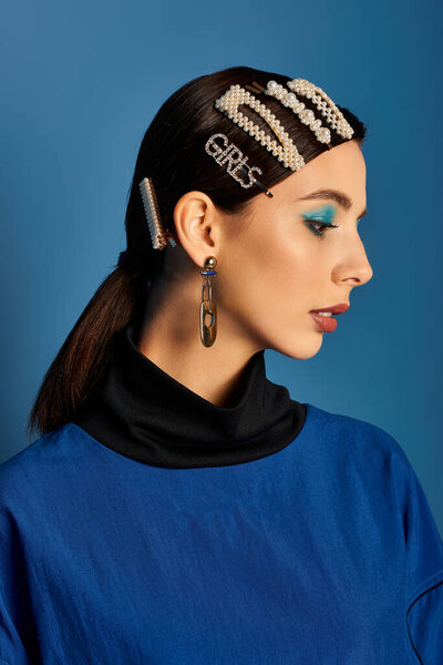 Молодая женщина уверенно позирует в стильной одежде, с шикарными заколками для волос.