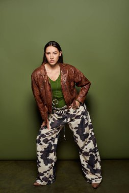 Kendine güvenen genç esmer, modaya uygun pozlar veriyor. Benzersiz şablonlar ve hareketli bir ortam..