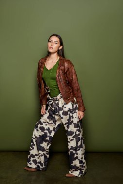 Göz kamaştırıcı esmer kadın rahat giysiler içinde, moda anlayışını ve çekiciliğini sergiliyor..