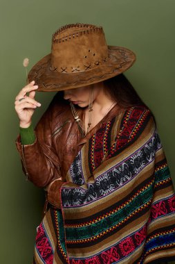 A stunning brunette embraces her culture with a beautifully patterned poncho and hat. clipart