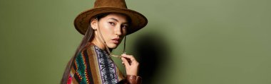 Renkli kıyafetli esmer kadın düşünceli bir ifadeyle moda anlayışını sergiliyor.