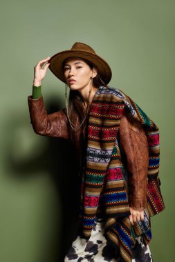 Genç esmer sporcu çarpıcı bir moda tarzıyla renkli bir şal ve şapka giyiyor.