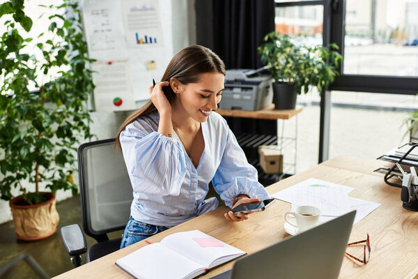 Brunette woman smiles as she checks her phone, surrounded by plants and a creative workspace.