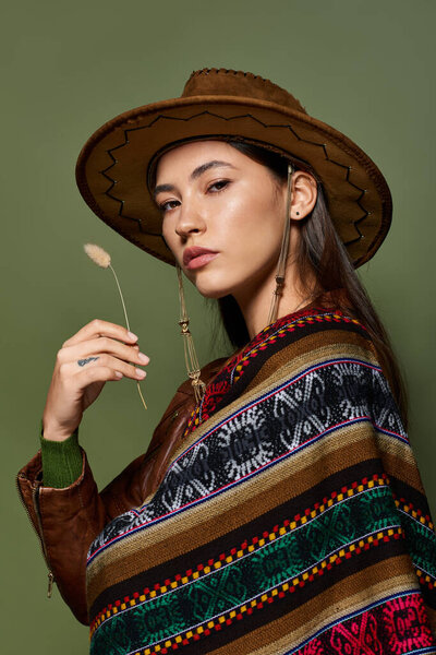 A confident young brunette shines in a vibrant, traditional outfit, posing gracefully.