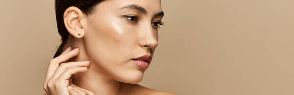 Брюнетка нежно прикасается к лицу, подчеркивая сияющую кожу и спокойное выражение лица.