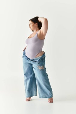 Genç bir kadın modaya uygun kıyafetlerini parlak ve minimalist bir alanda sergiliyor..