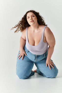 Kendine güvenen genç bir kadın şık bir kıyafetle diz çöker ve eşsiz moda anlayışını gösterir..