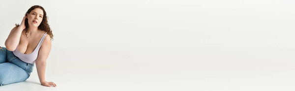 Стильная молодая женщина уверенно позирует в повседневной, но модной одежде на чистом фоне.