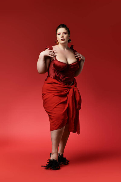 Young woman showcases trendy fashion and charisma against a bold red background.