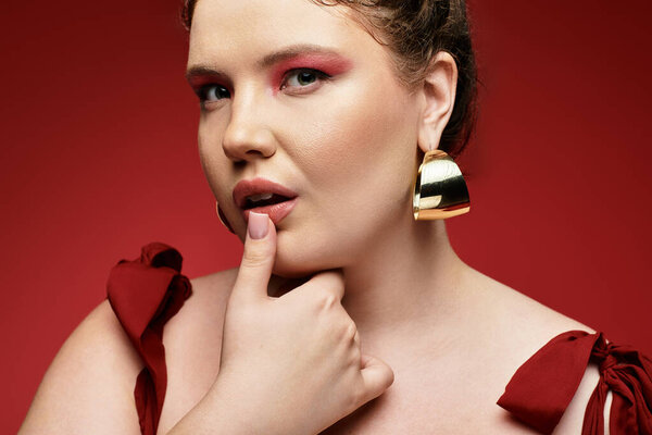 Стильная молодая женщина задумчиво позирует, демонстрируя свое уникальное чувство стиля и яркий стиль.