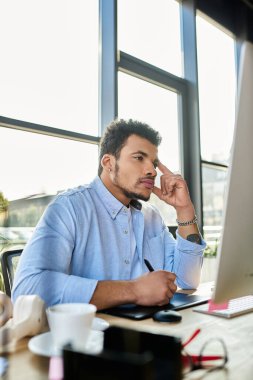 Yakışıklı adam güneşli ofis manzarasının tadını çıkarırken dijital bir projede çalışıyor..