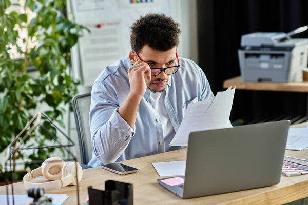 Handsome man analyzes important documents while concentrating at a modern desk during the day.