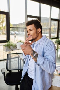 A stylish man sips coffee and chats on the phone in a chic office filled with natural light. clipart