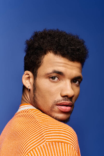 A charming man showcases his captivating expression while looking over his shoulder.