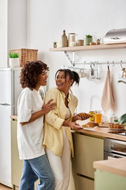 Genç bir çift, şık evlerinde sıcak bir kahvaltıda kahkaha ve sevgiyi paylaşıyor..