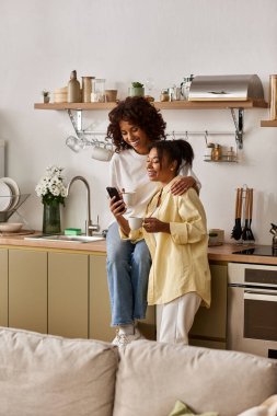 Genç bir Afrikalı Amerikalı çift modern mutfaklarında kahkaha ve sevgiyi paylaşıyor..